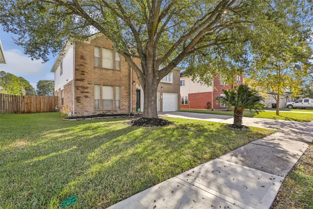 a view of a house with a yard and tree s