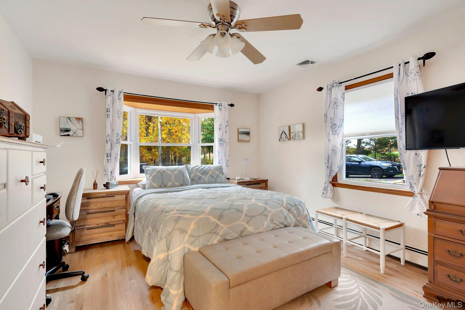 210 3rd Street Laurel, NY 11948 - Photo 11 of 22 Bedroom featuring a baseboard radiator, light wood-style flooring, and ceiling fan