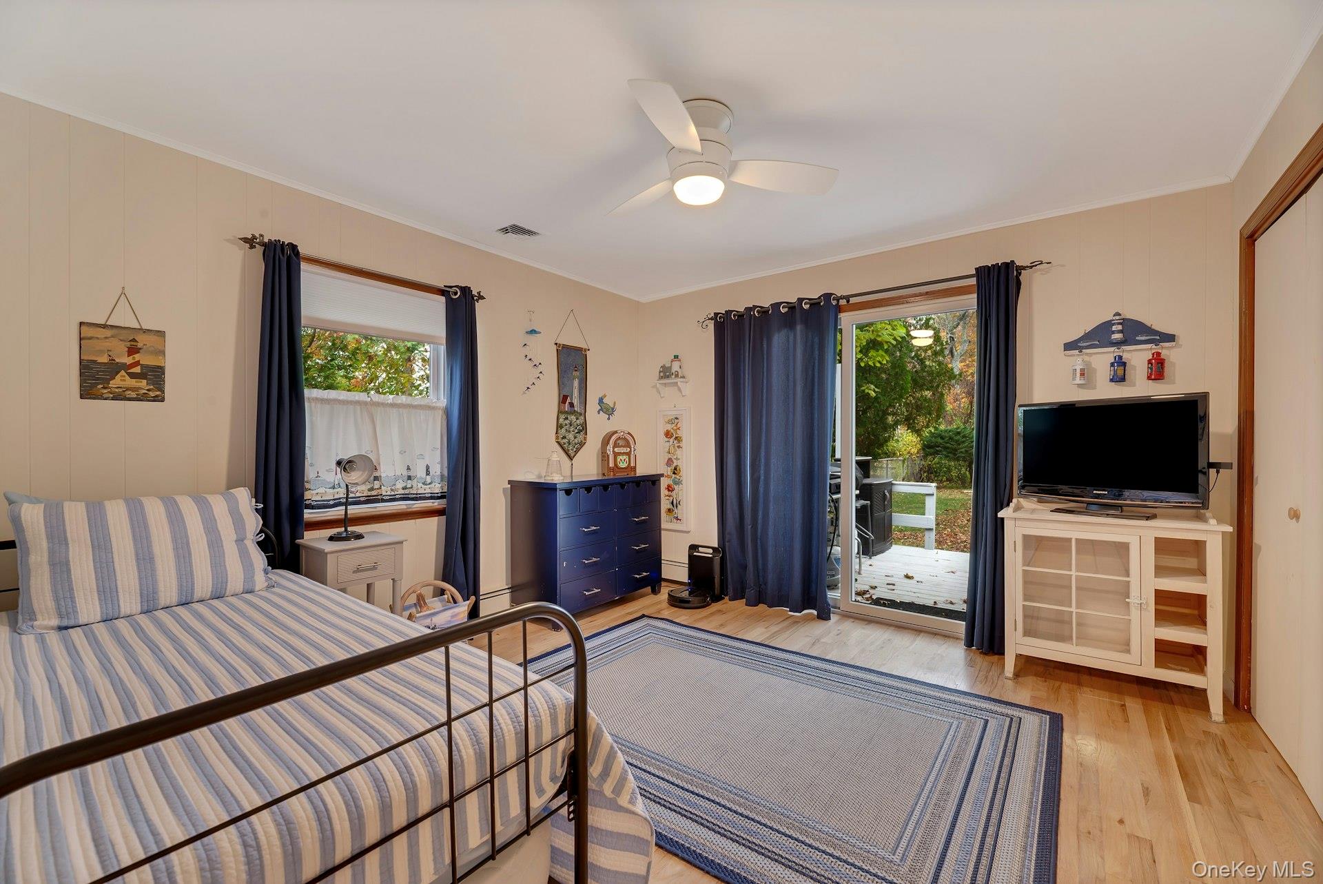 210 3rd Street Laurel, NY 11948 - Photo 13 of 22 Bedroom with light wood-style flooring, multiple windows, access to exterior, ceiling fan, and crown molding