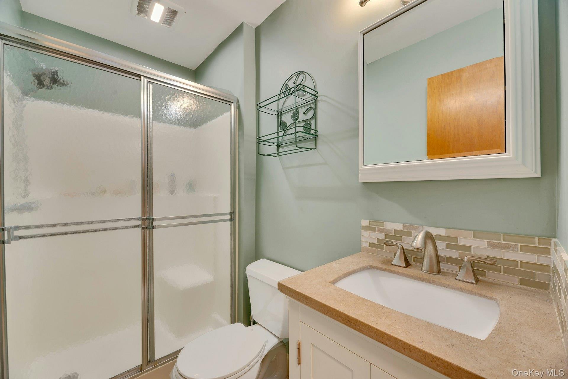210 3rd Street Laurel, NY 11948 - Photo 18 of 22 Bathroom with backsplash, vanity, and a stall shower