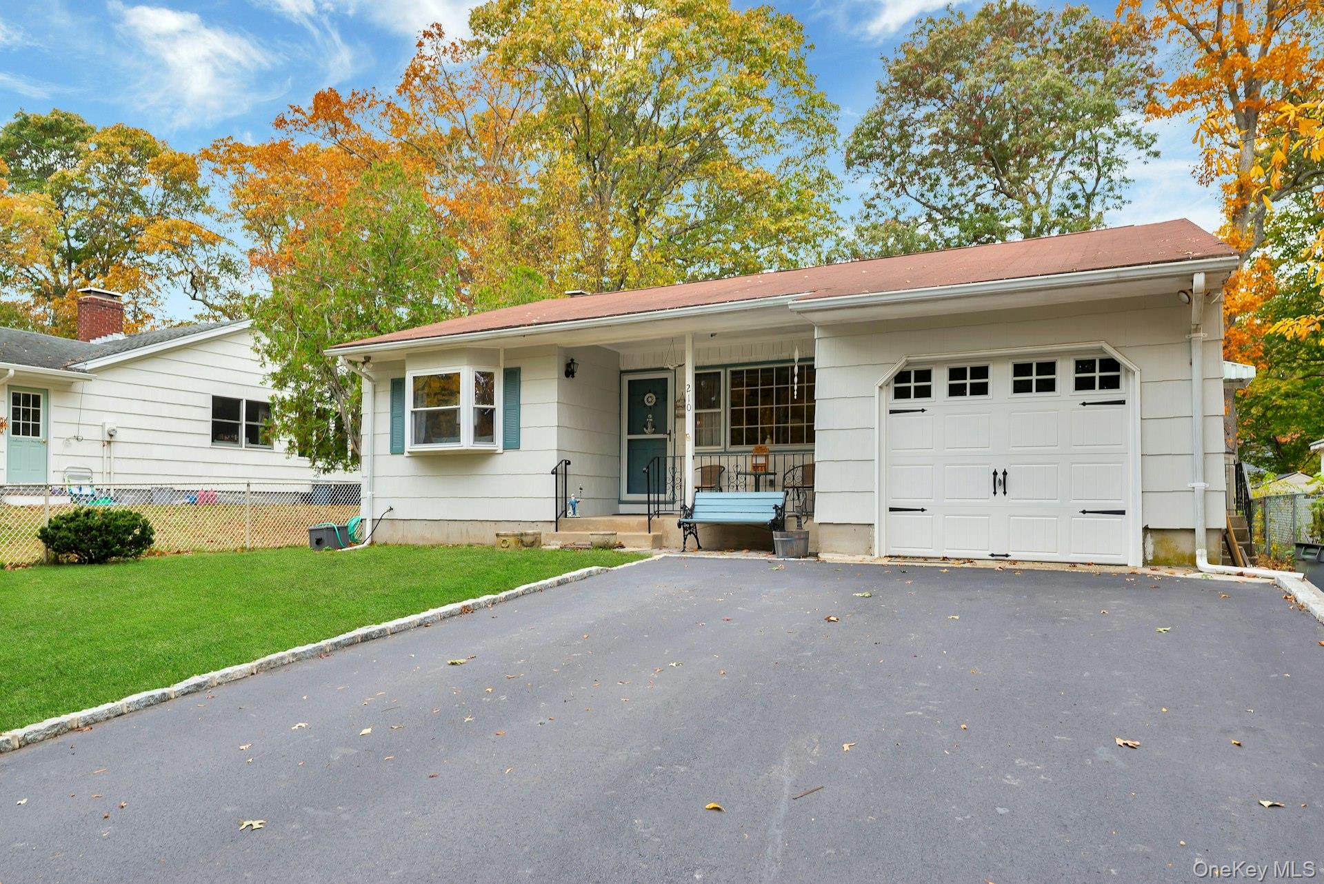 210 3rd Street Laurel, NY 11948 - Photo 3 of 22 Ranch-style home featuring asphalt driveway, covered porch, and an attached garage