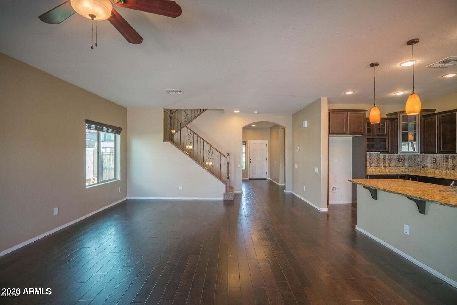 10786 West Yearling Road Peoria, AZ 85383 - Photo 2 of 21 a view of a room with wooden floor and a ceiling fan