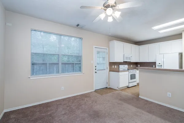 an empty room with chandelier fan