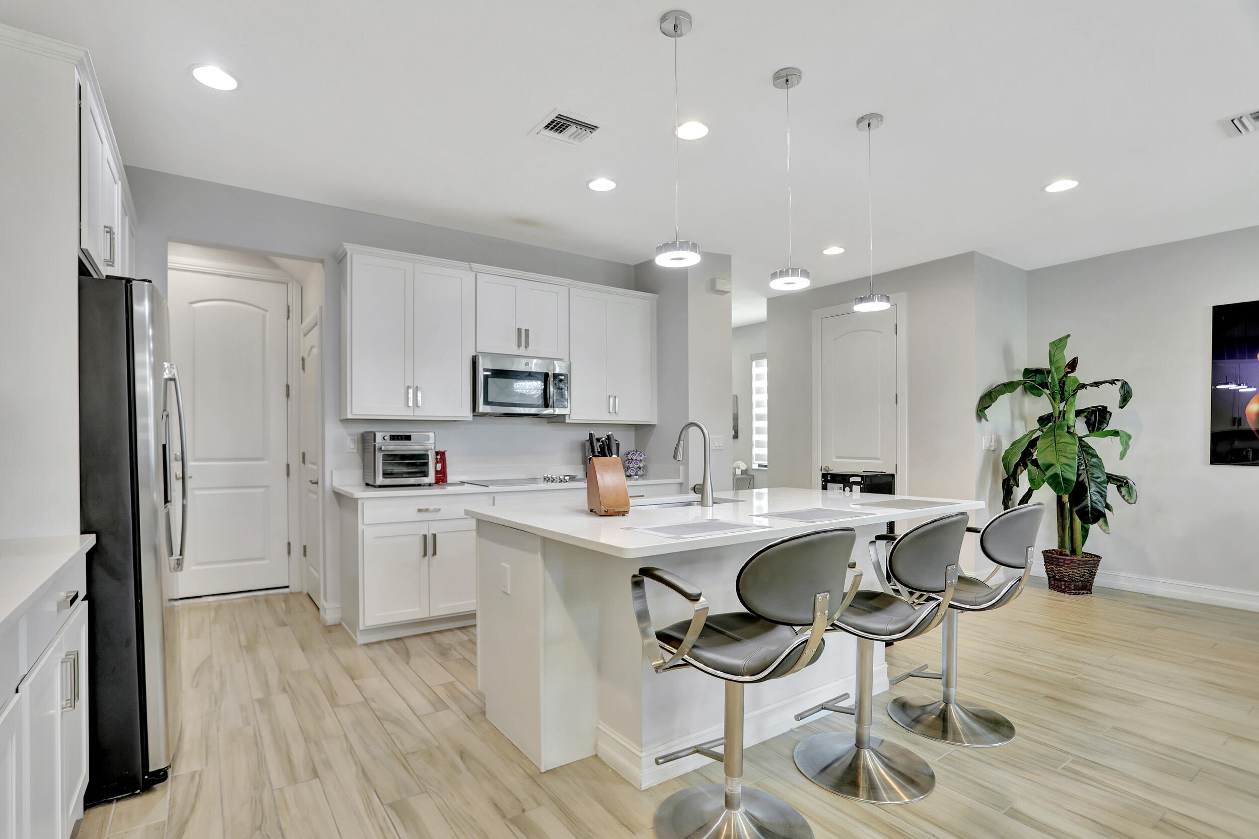 9517 Glider Way Boca Raton, FL 33428 - Photo 13 of 60 a kitchen with white cabinets and stainless steel appliances