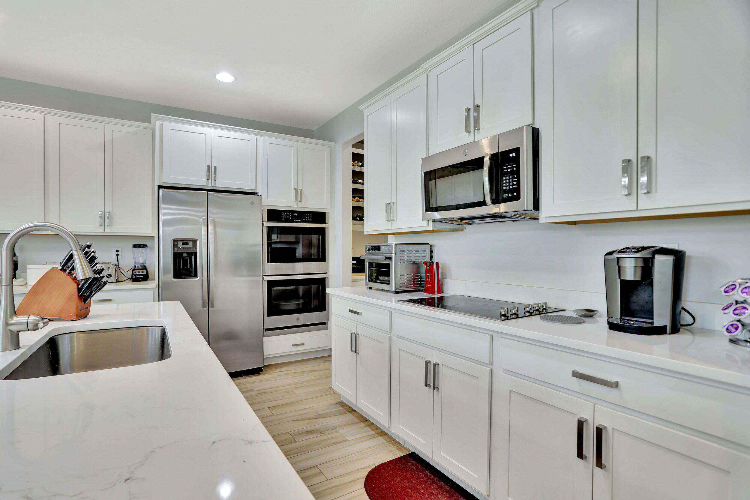 9517 Glider Way Boca Raton, FL 33428 - Photo 22 of 60 a kitchen with stainless steel appliances granite countertop white cabinets a microwave a sink and a refrigerator