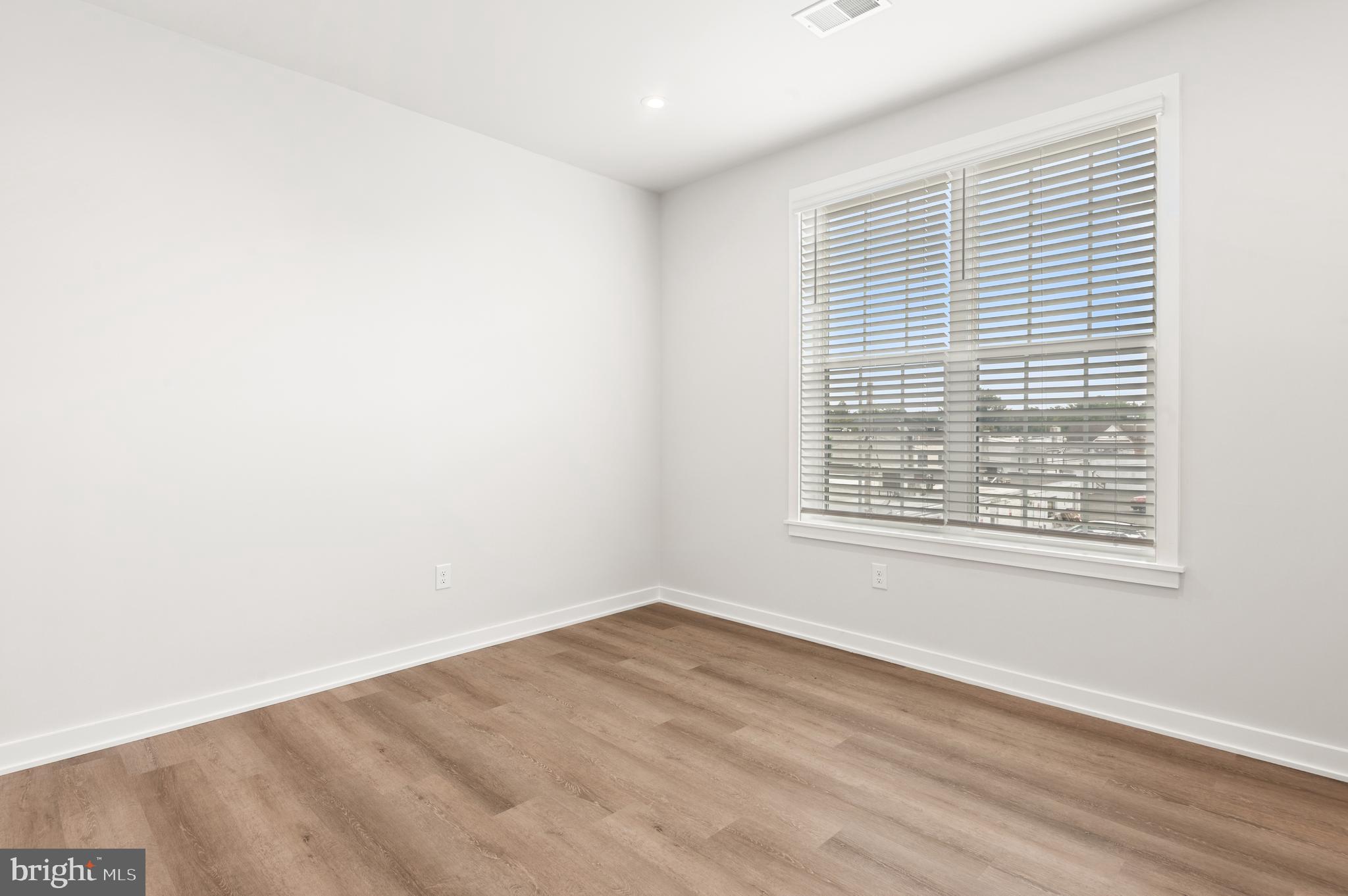 26 South York Road, Unit 401 Hatboro, PA 19040 - Photo 18 of 54 a view of an empty room with wooden floor and a window
