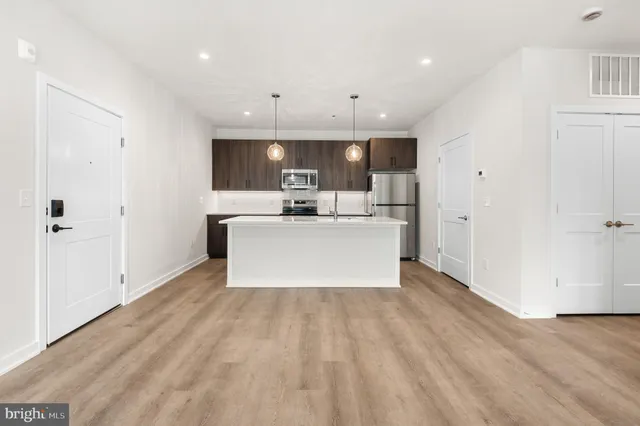 a view of a kitchen with cabinets stainless steel appliances a sink and a window