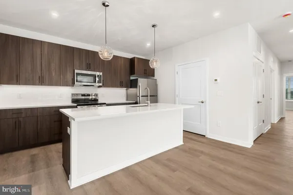 a kitchen with kitchen island a sink stainless steel appliances and cabinets
