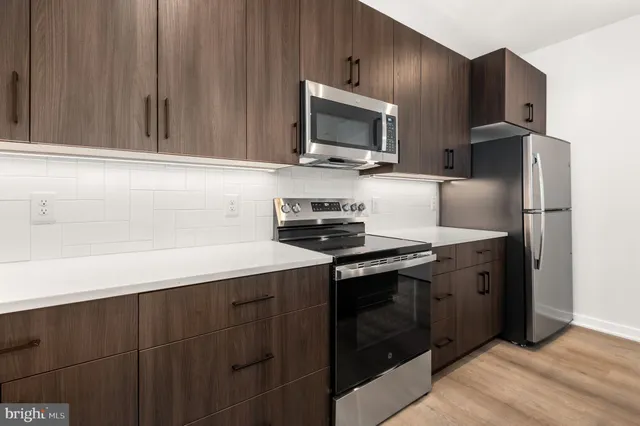 a kitchen with stainless steel appliances a stove microwave and refrigerator
