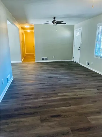 a view of empty room with wooden floor
