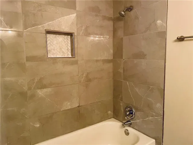 a bathroom with a bathtub and shower