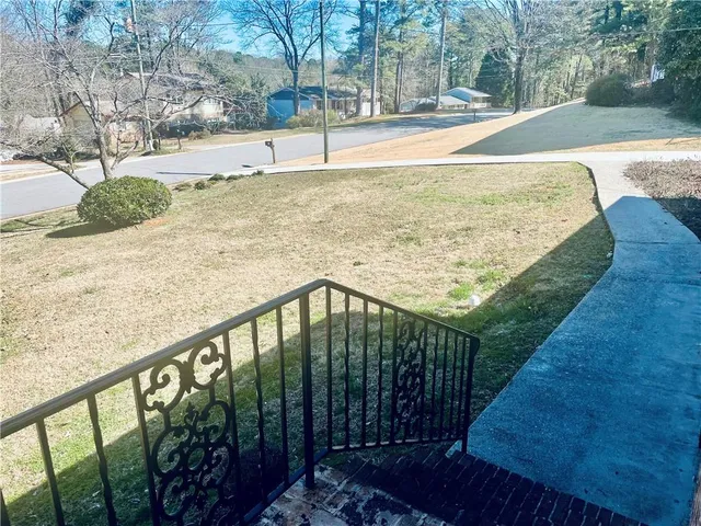 a view of a yard with wooden fence