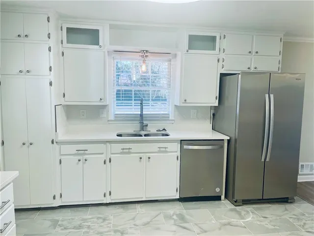 a kitchen with stainless steel appliances granite countertop a refrigerator sink and cabinets