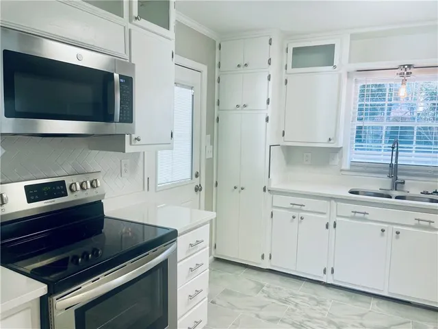 a kitchen with stainless steel appliances a stove a microwave and a sink