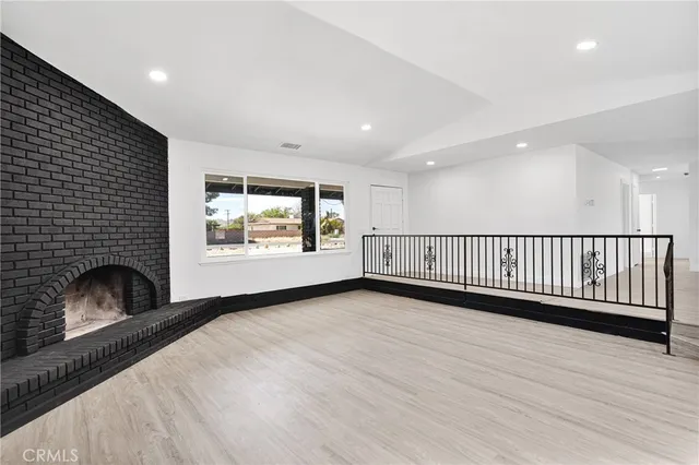 a view of an empty room with a fireplace and a window
