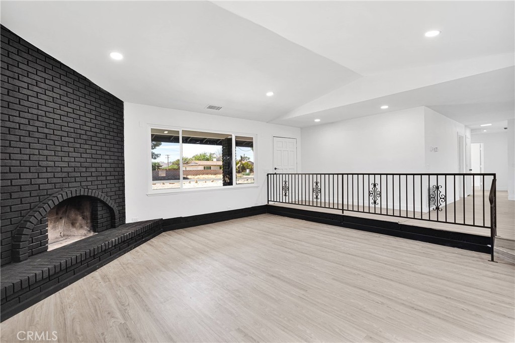 14855 Flathead Road Apple Valley, CA 92307 - Photo 3 of 14 a view of an empty room with a fireplace and a window