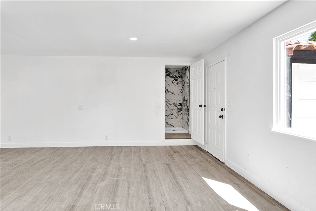14855 Flathead Road Apple Valley, CA 92307 - Photo 10 of 14 an empty room with wooden floor and windows