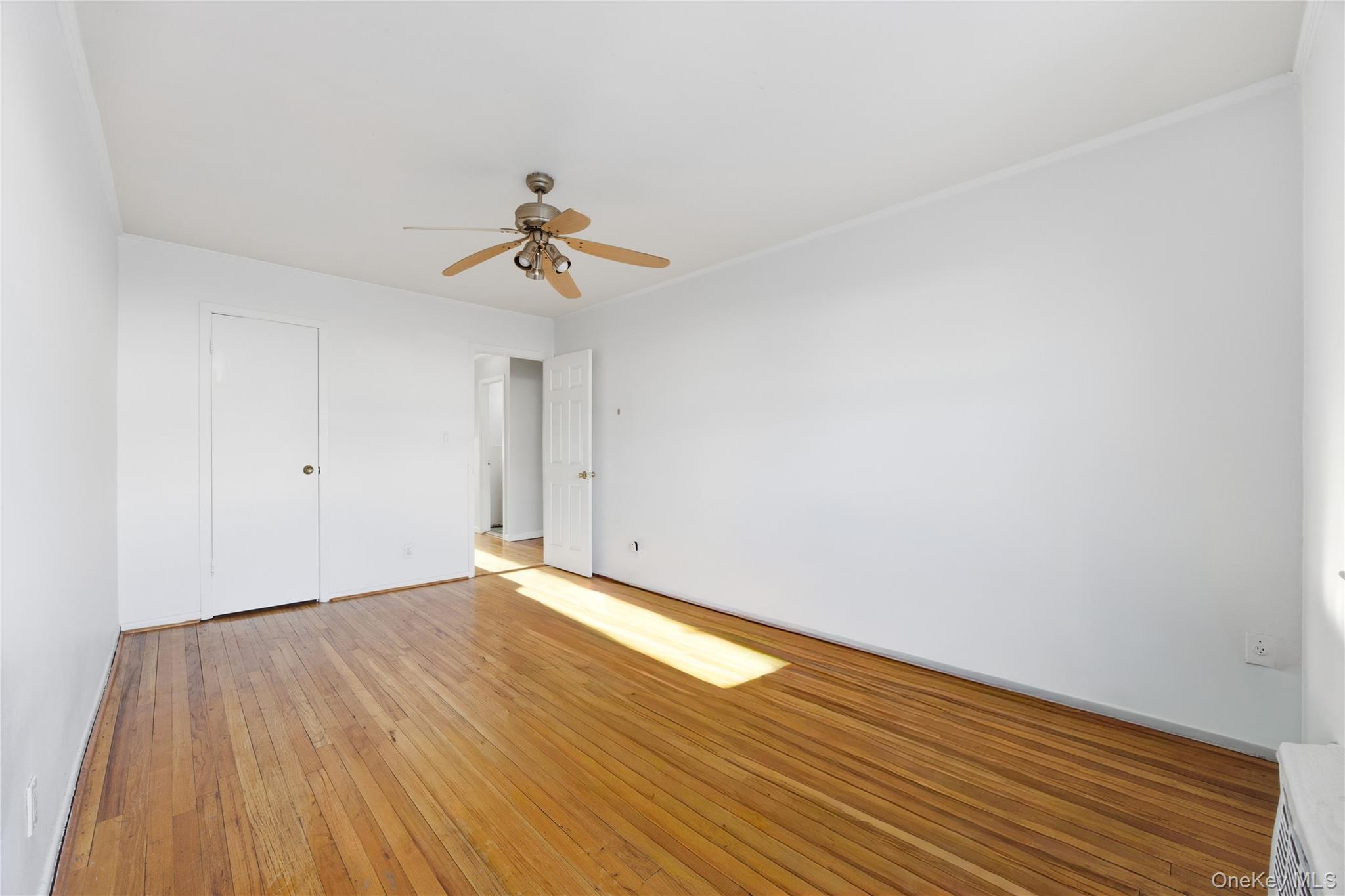 5-37 117th Street Queens, NY 11356 - Photo 12 of 28 a view of an empty room with wooden floor