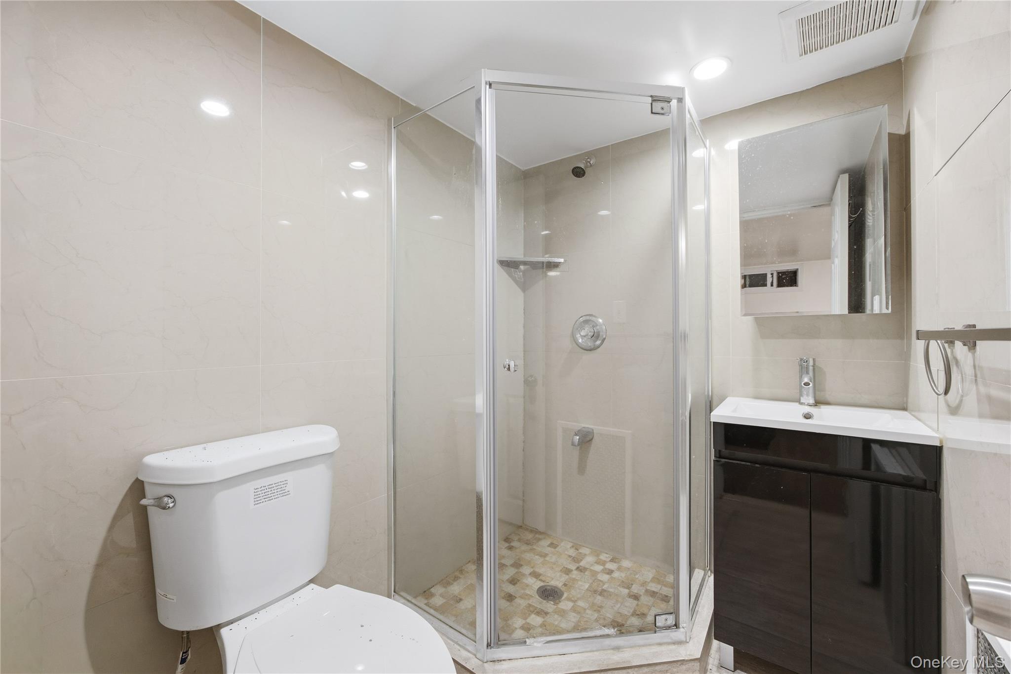 5-37 117th Street Queens, NY 11356 - Photo 17 of 28 a white toilet sitting next to a bathroom sink
