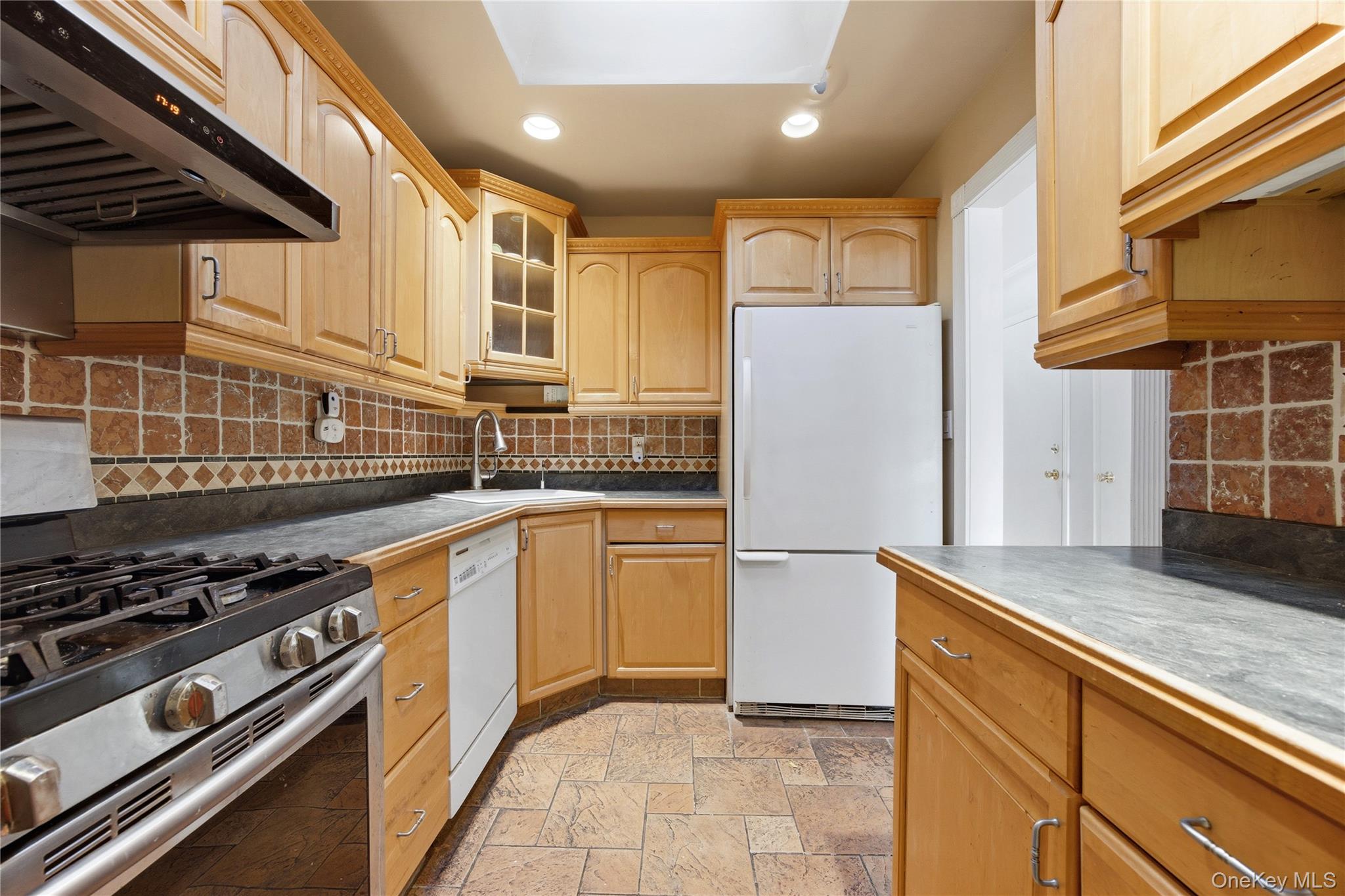 5-37 117th Street Queens, NY 11356 - Photo 4 of 28 a kitchen with stainless steel appliances granite countertop a stove a sink and a refrigerator