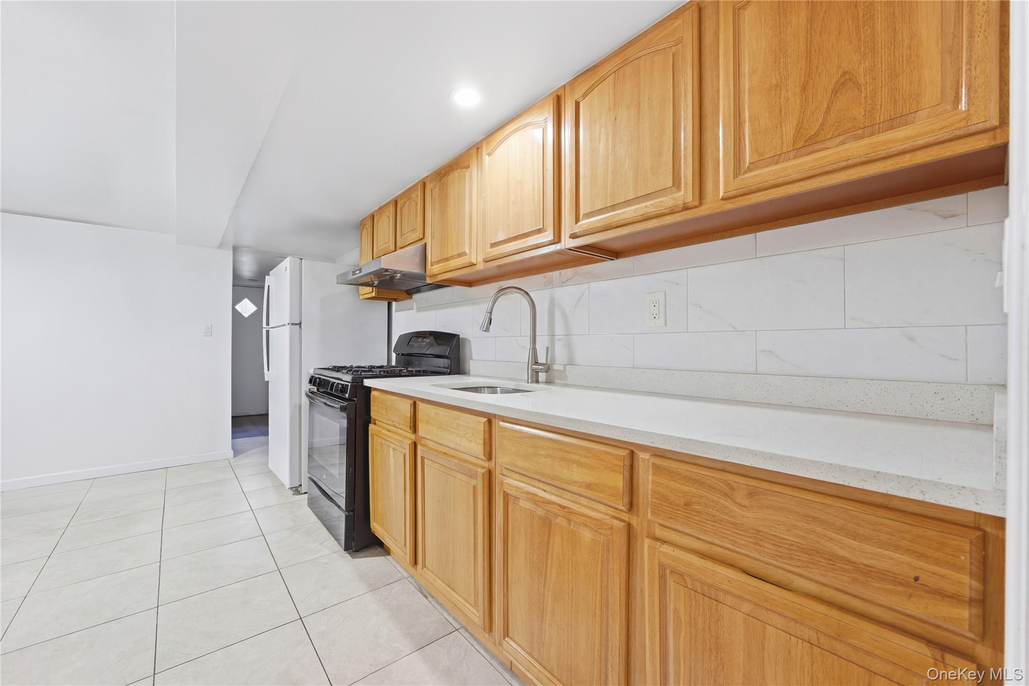 5-37 117th Street Queens, NY 11356 - Photo 5 of 28 a kitchen with granite countertop a sink and cabinets