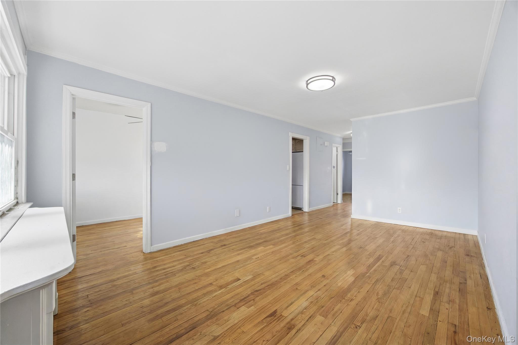 5-37 117th Street Queens, NY 11356 - Photo 7 of 28 a view of an empty room with wooden floor and a window