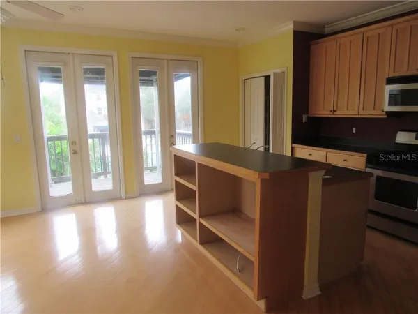 a view of a kitchen with kitchen island a sink wooden floor and a window