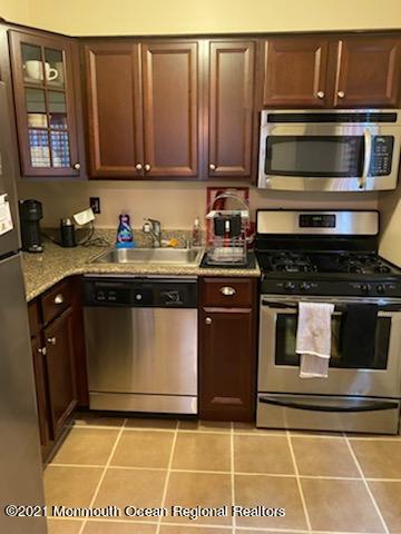400 Cross Road, Unit A7 Matawan, NJ 07747 - Photo 2 of 10 a kitchen with granite countertop a stove a microwave a sink and cabinets