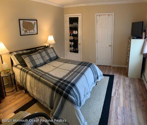 400 Cross Road, Unit A7 Matawan, NJ 07747 - Photo 5 of 10 a bedroom with a bed and wooden floor