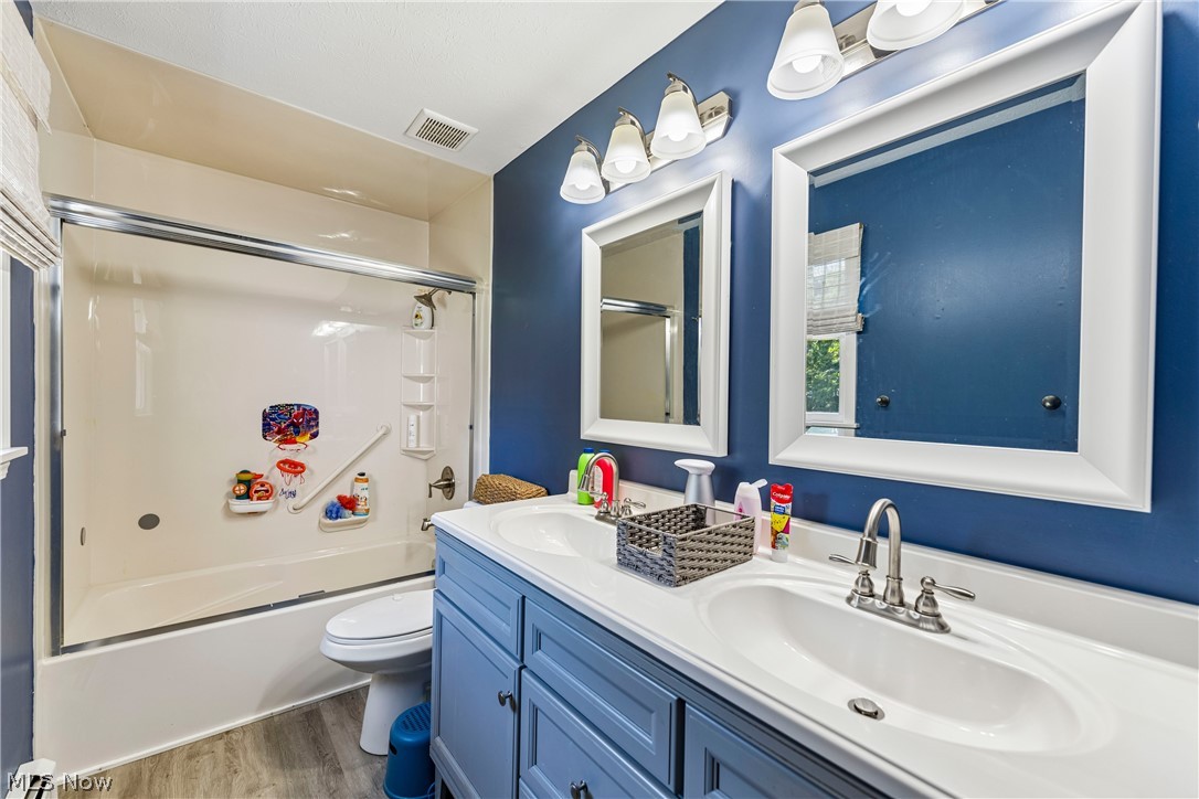 6711 Norwalk Road Medina, OH 44256 - Photo 20 of 46 Second floor full bathroom with double sink, vanity, shower /tub combo, decorative lighting, commode and LVT flooring