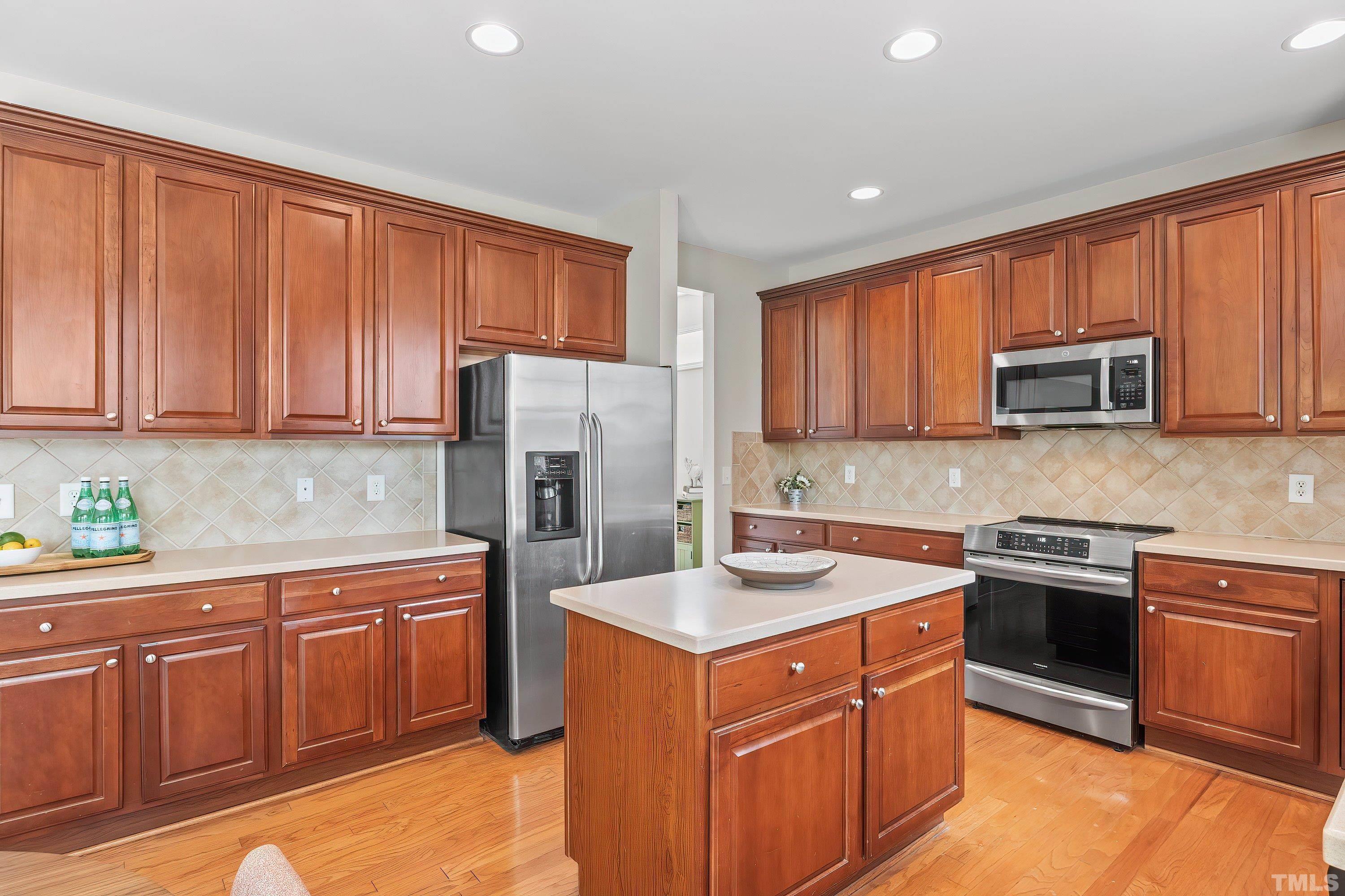 5225 Holly Ridge Farm Road Raleigh, NC 27616 - Photo 18 of 61 a kitchen with stainless steel appliances granite countertop a stove top oven a sink dishwasher and a refrigerator with wooden cabinets