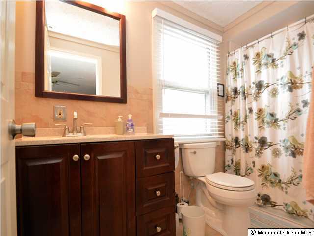 201 Forman Avenue Point Pleasant Beach, NJ 08742 - Photo 20 of 25 a bathroom with a toilet a sink a mirror a window and vanity