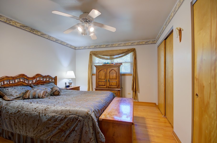 23019 South Kent Road Channahon, IL 60410 - Photo 26 of 36 a bedroom with a bed and a chandelier