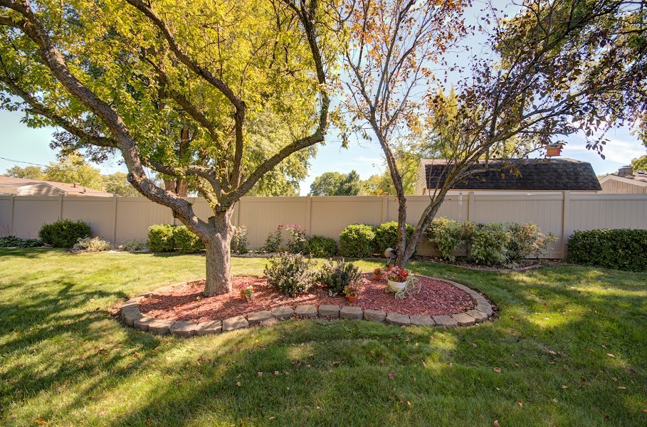 23019 South Kent Road Channahon, IL 60410 - Photo 6 of 36 a backyard of a house with table and chairs under an umbrella