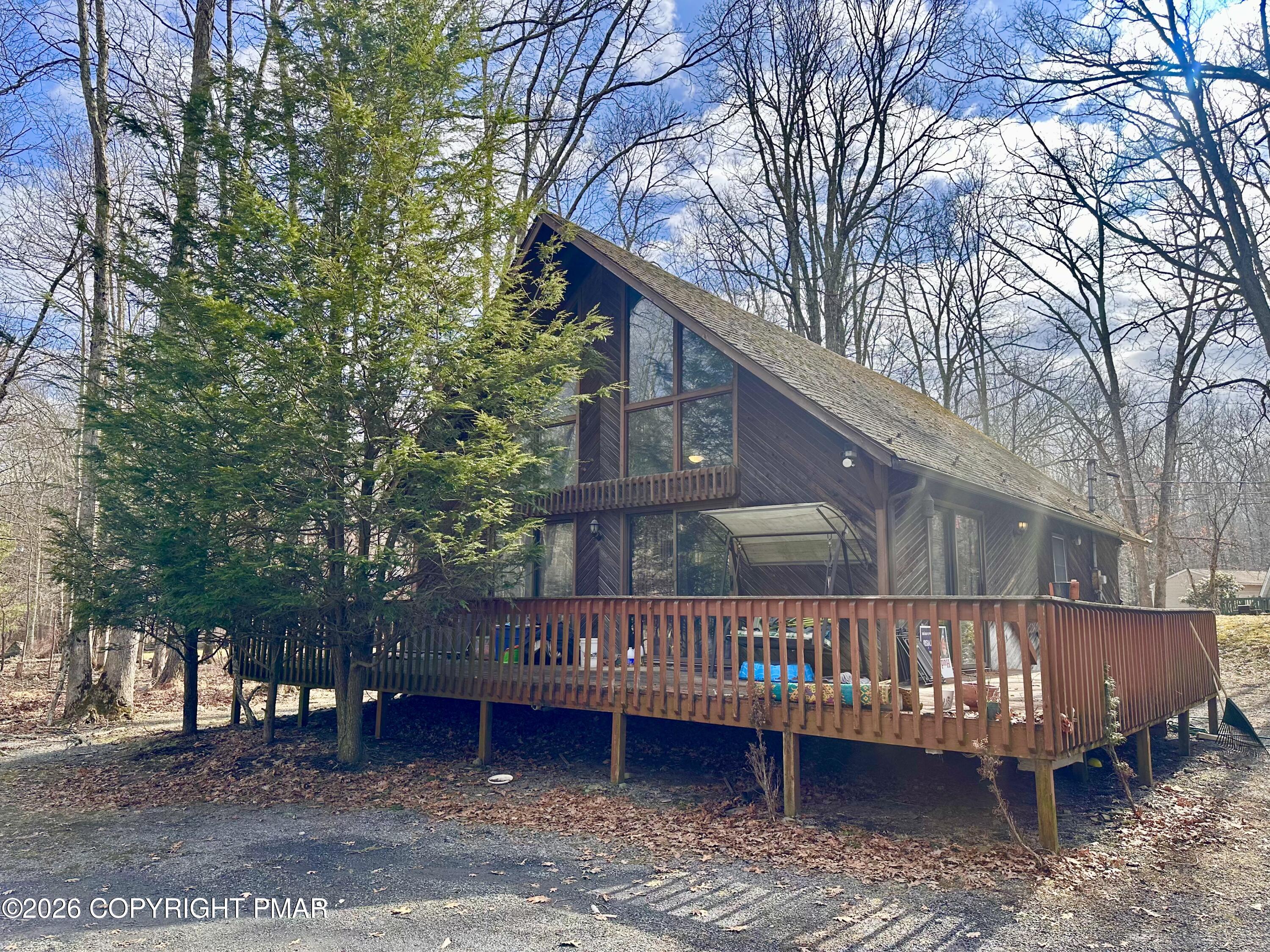 a view of a house with a yard and wooden deck