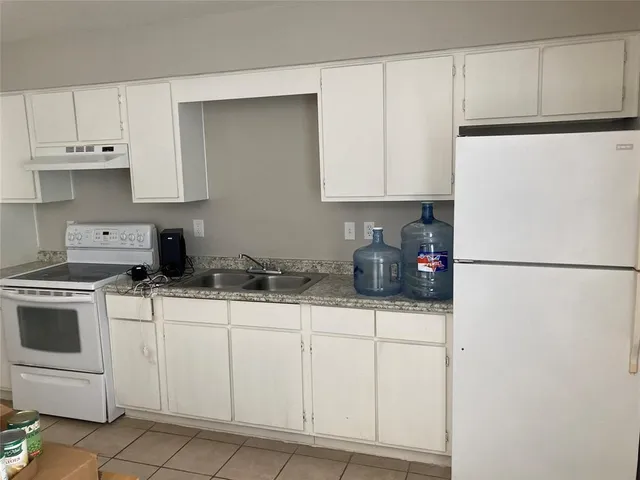 a kitchen with white cabinets and white appliances