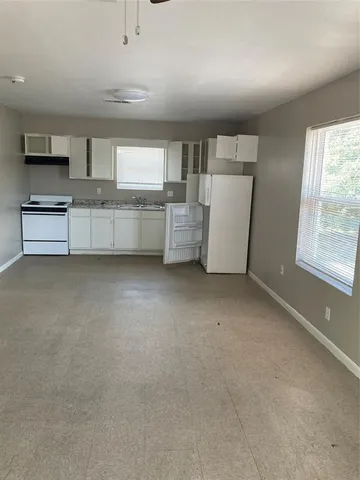 a view of a kitchen with refrigerator and windows
