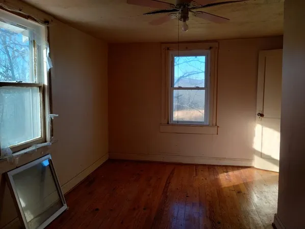 a view of a livingroom with wooden floor and a ceiling fan