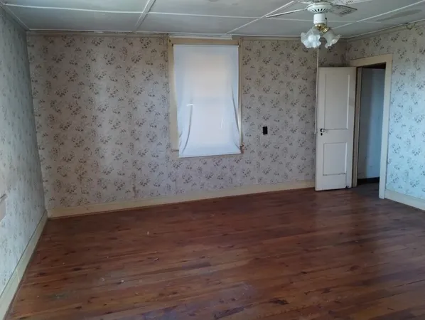 a view of a room with wooden floor and a window