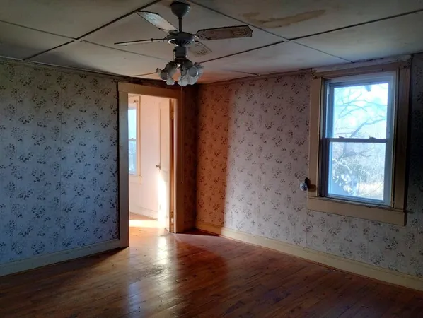 a view of an empty room with wooden floor