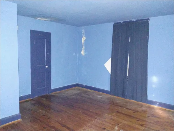 a view of an entryway with wooden floor windows and a chandelier