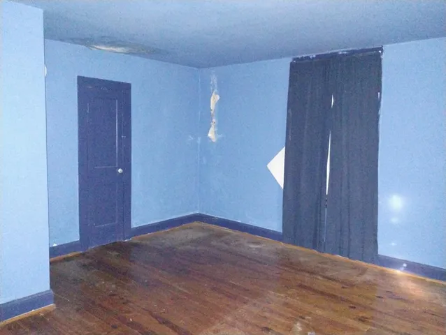 a view of an entryway with wooden floor windows and a chandelier