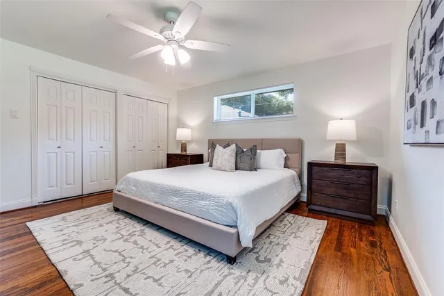 a bedroom with a bed and a lamp on dresser