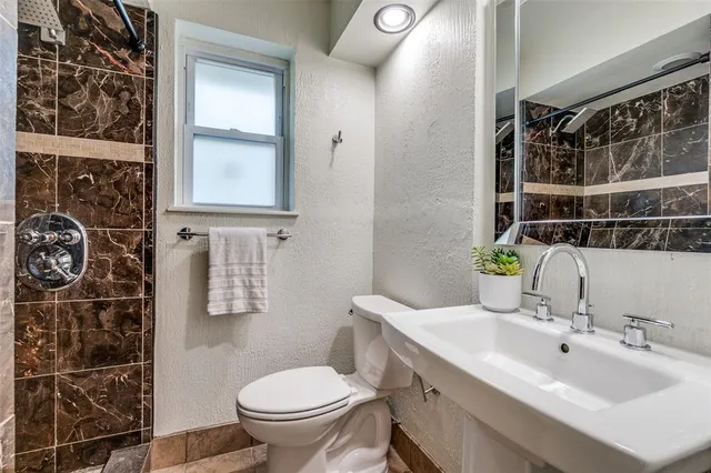 a bathroom with a sink toilet and shower