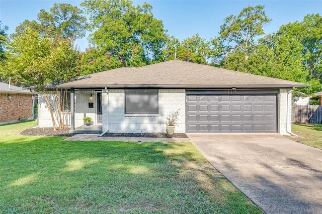 a front view of a house with a garden and yard