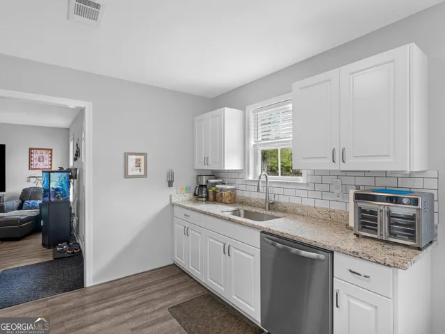 a kitchen with stainless steel appliances granite countertop a sink stove and cabinets
