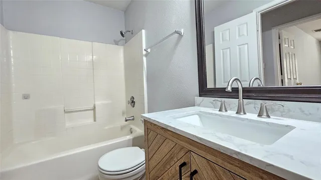 a bathroom with a sink a toilet and a large mirror