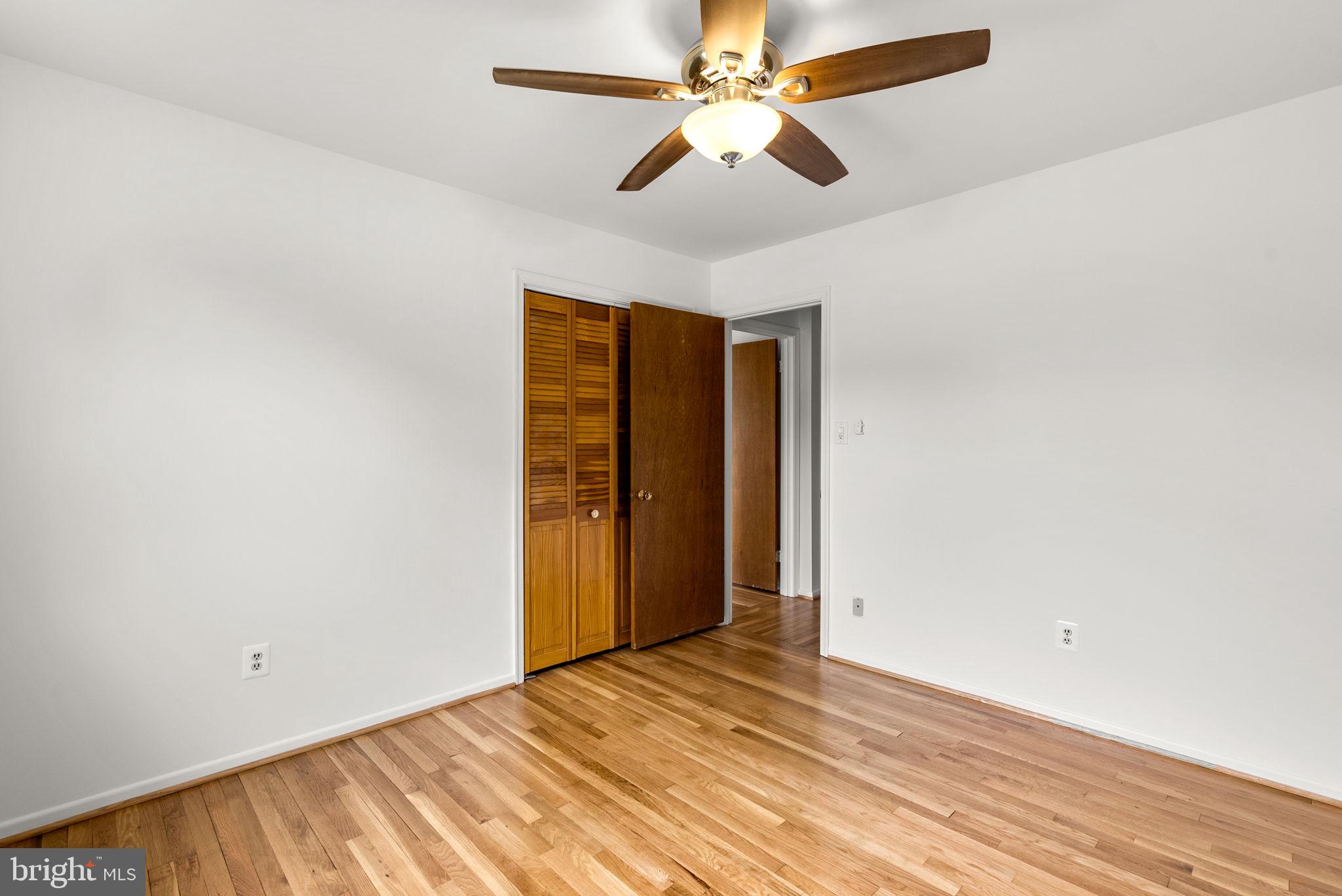 18724 Bloomfield Road Olney, MD 20832 - Photo 18 of 32 an empty room with a ceiling fan and wooden floor