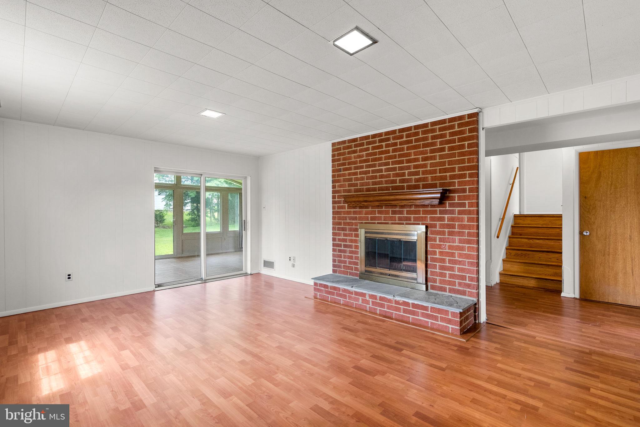 18724 Bloomfield Road Olney, MD 20832 - Photo 20 of 32 an empty room with wooden floor fireplace and windows