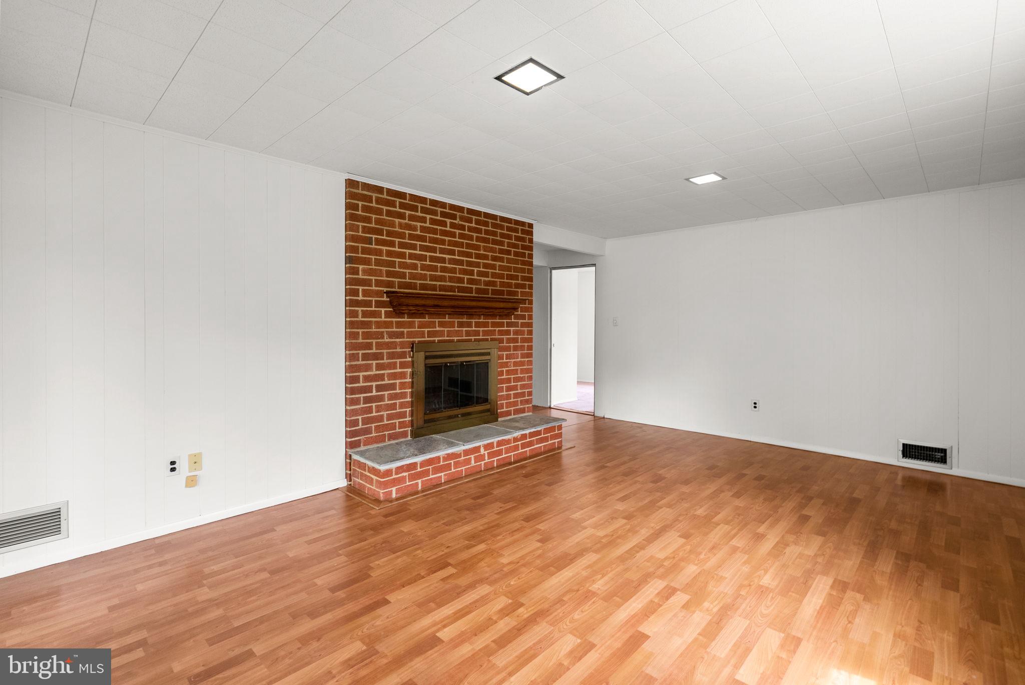 18724 Bloomfield Road Olney, MD 20832 - Photo 21 of 32 a view of empty room with wooden floor and fireplace